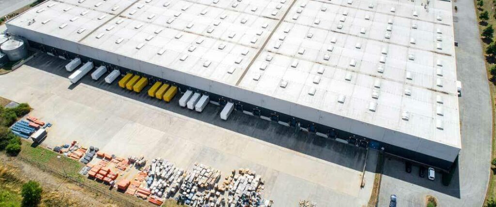 An aerial view of a 3PL warehouse with semi trucks docked to it