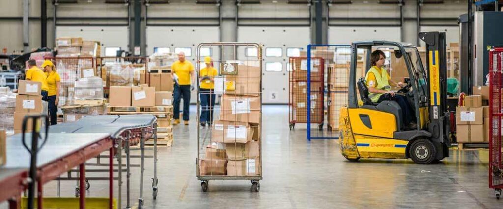 The benefits of a 3PL for retail order fulfillment on display in a warehouse populated by several workers.