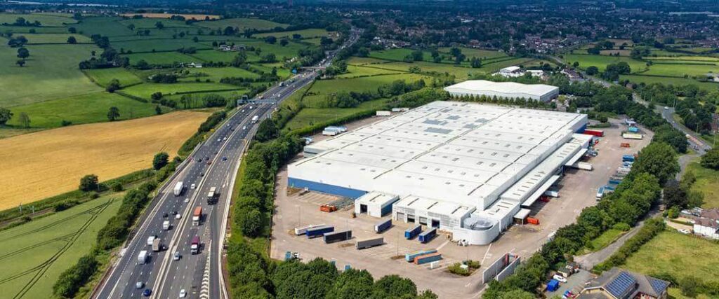 Aerial view of warehouse center by a highway. 