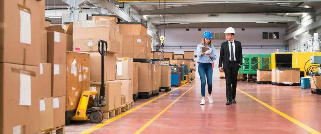 Two warehouse workers inspecting palletized cargo.