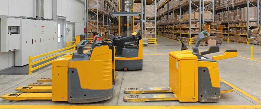 Three forklifts parked inside a third-party logistics warehouse.