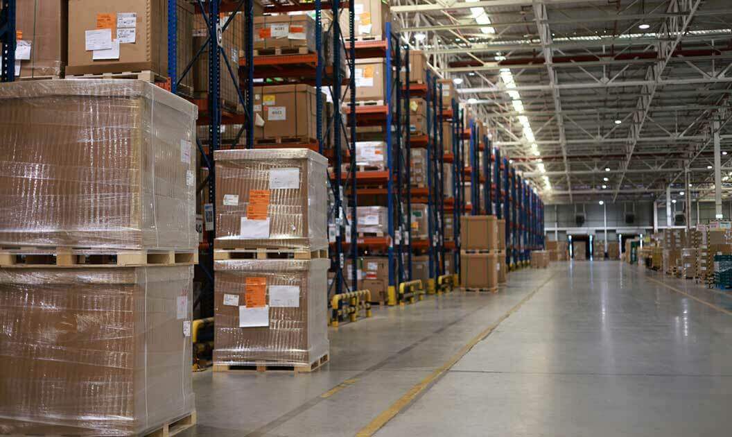 Rows of shelves holding palletized freight inside a warehouse