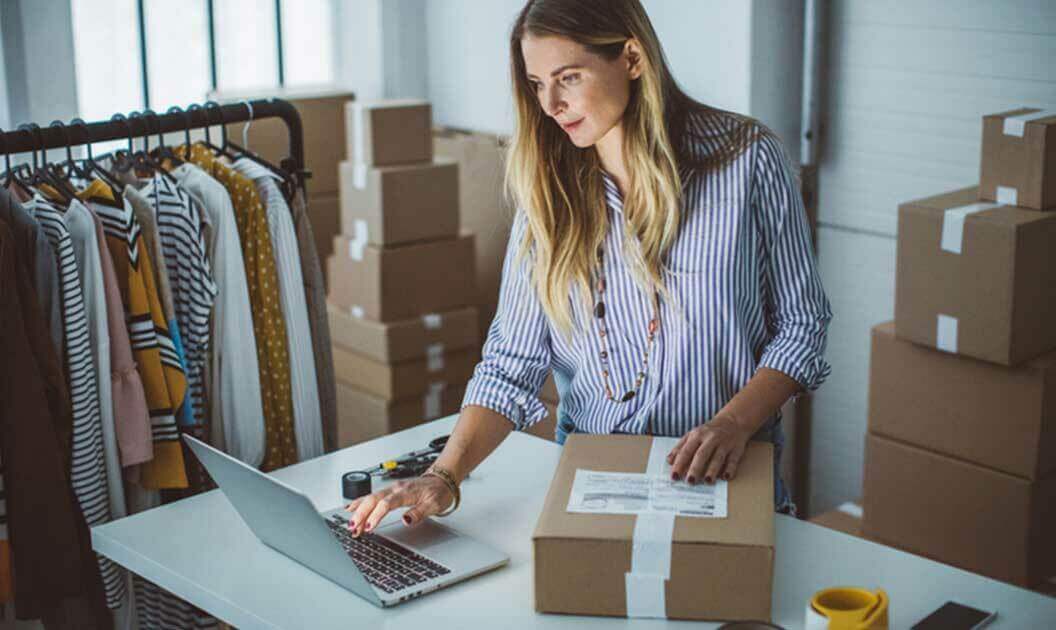 A woman that runs an online clothing store getting ready to ship a package